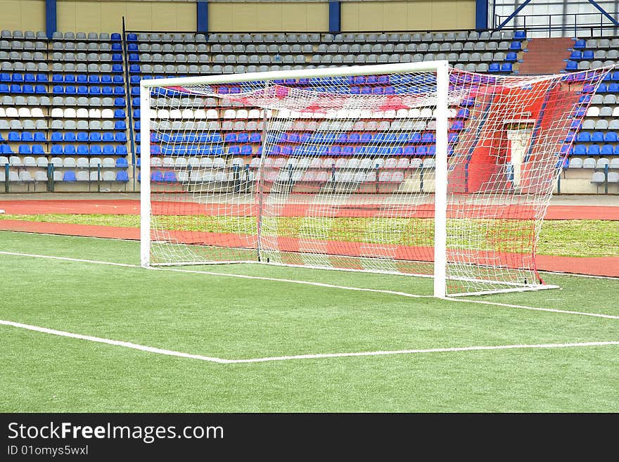 The image of a stadium and a goal under the foreground