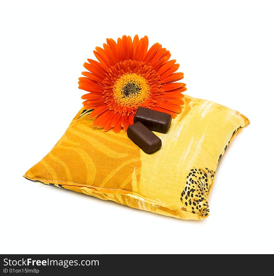 Candy and flower on pillow isolated on white