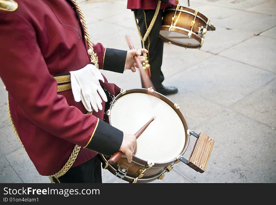 Uniformed musicians touching a drum. Uniformed musicians touching a drum