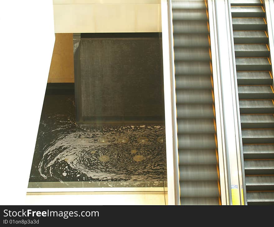 Two escalators next to a fountain