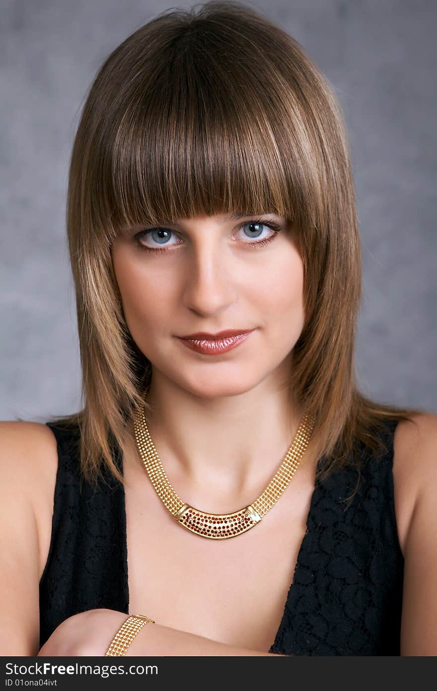 Girl in a black elegant dress on a grey background. Girl in a black elegant dress on a grey background