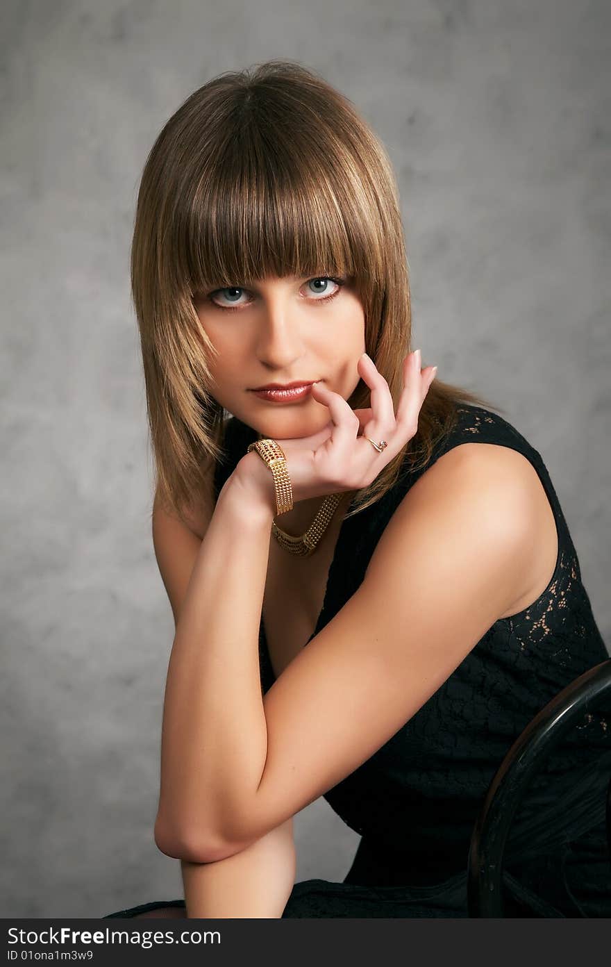 Girl in a black elegant dress on a grey background. Girl in a black elegant dress on a grey background