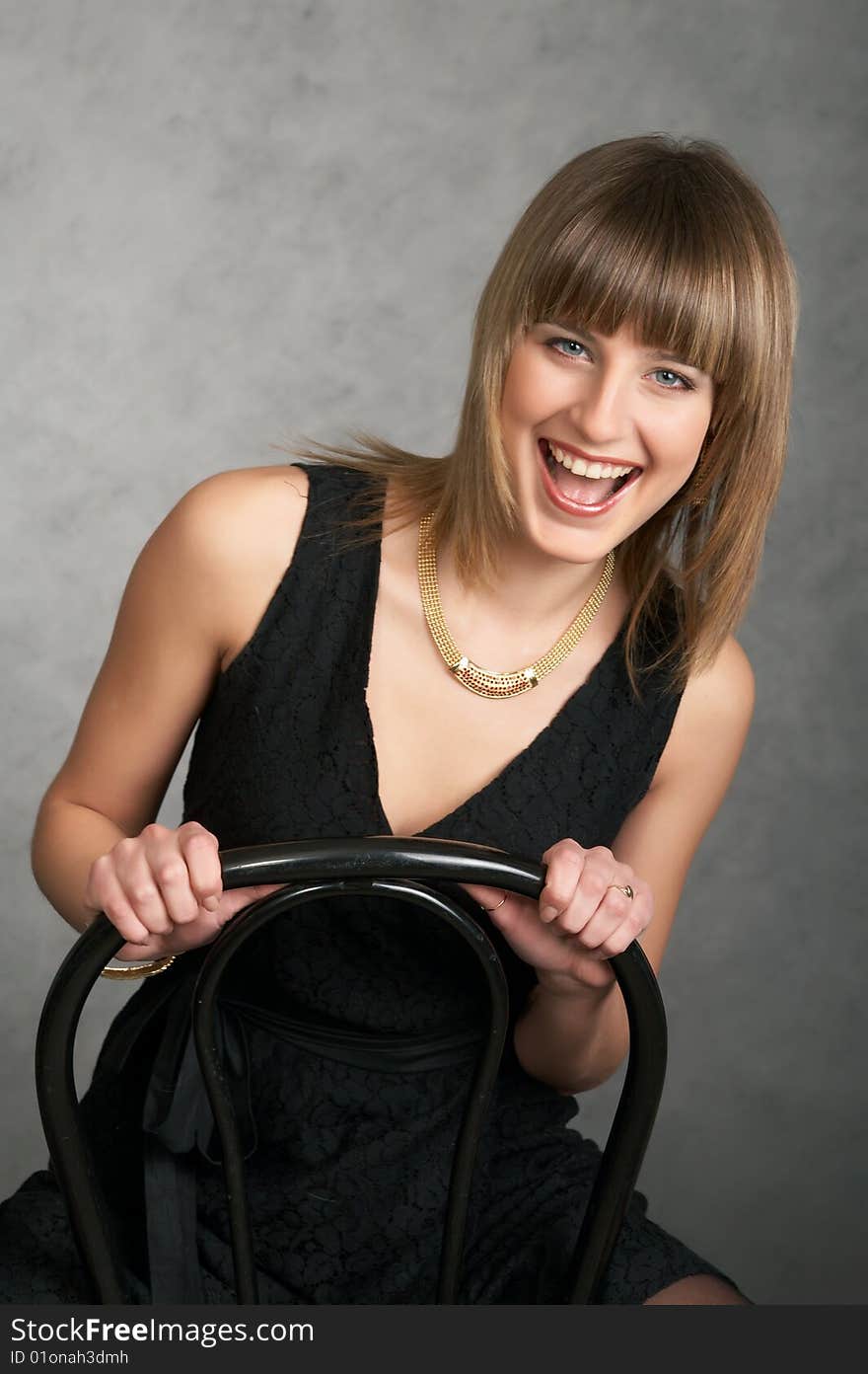 Girl in a black elegant dress on a grey background. Girl in a black elegant dress on a grey background