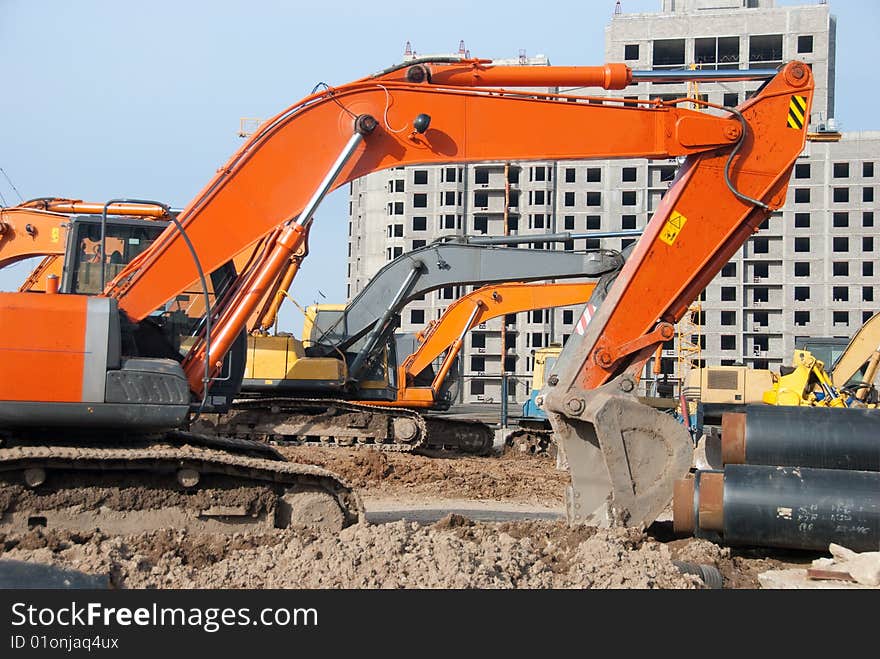 Excavators stand in a construction site