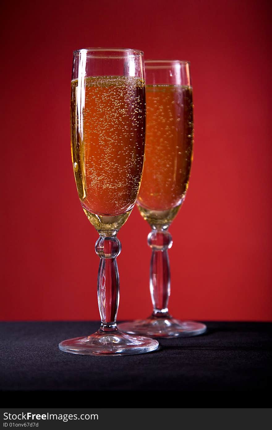 Champagne glasses over red background, selective focus