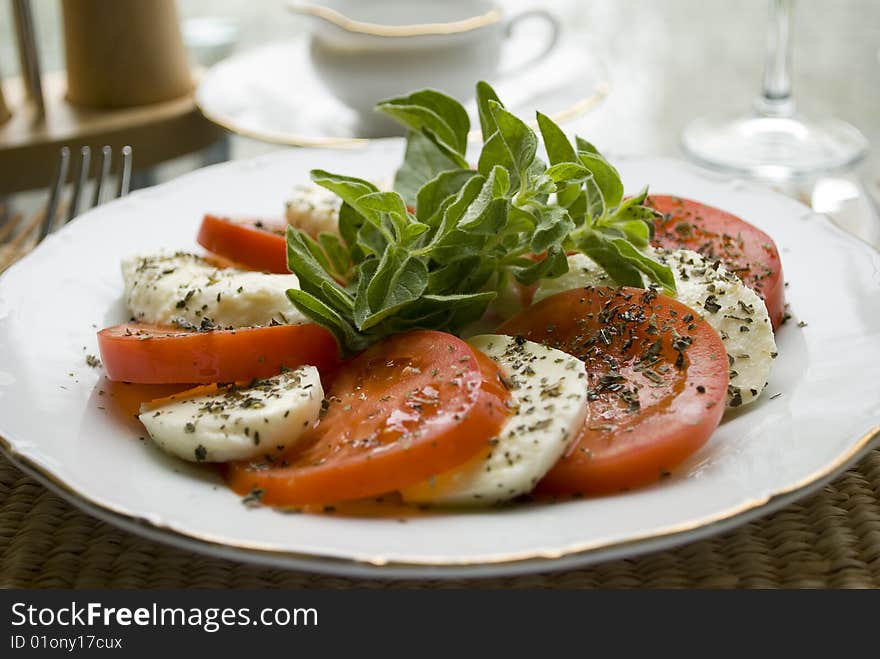 Slices of mozzerella and tomato with basilica. Slices of mozzerella and tomato with basilica