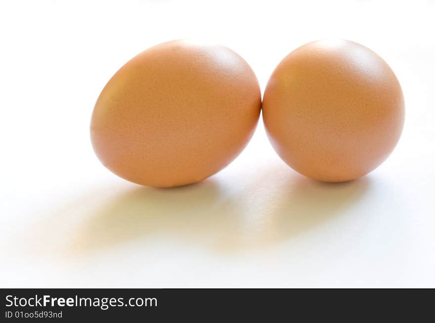 Two brown eggs with soft shadows