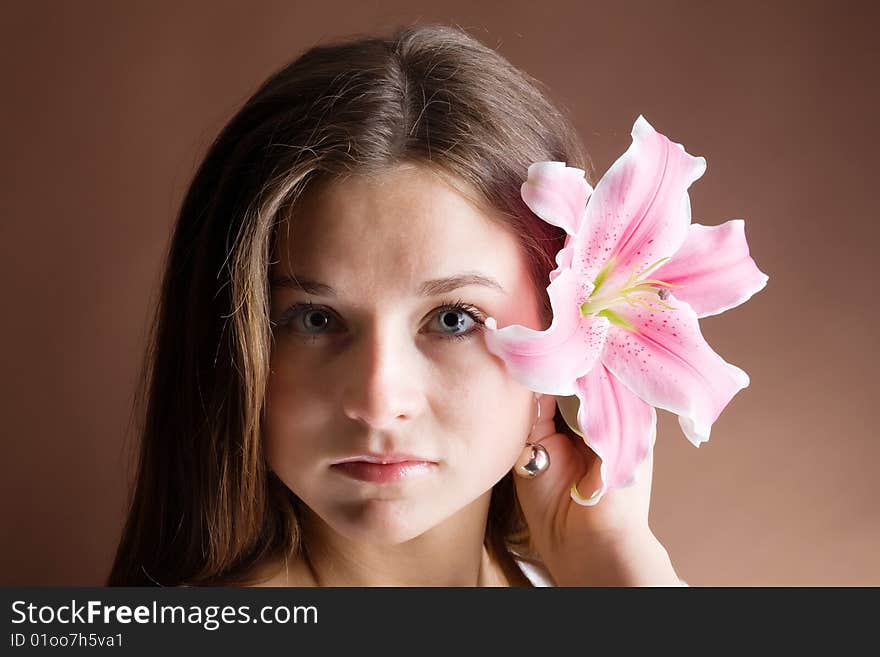 Young woman posing with a pink lily