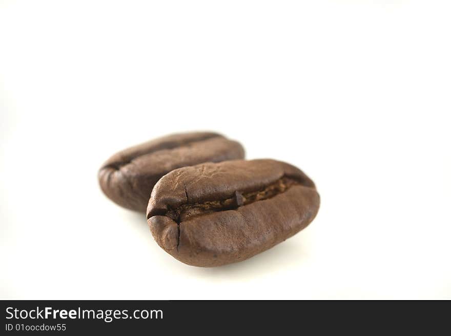 Two coffee beans in white background, close up. Two coffee beans in white background, close up.