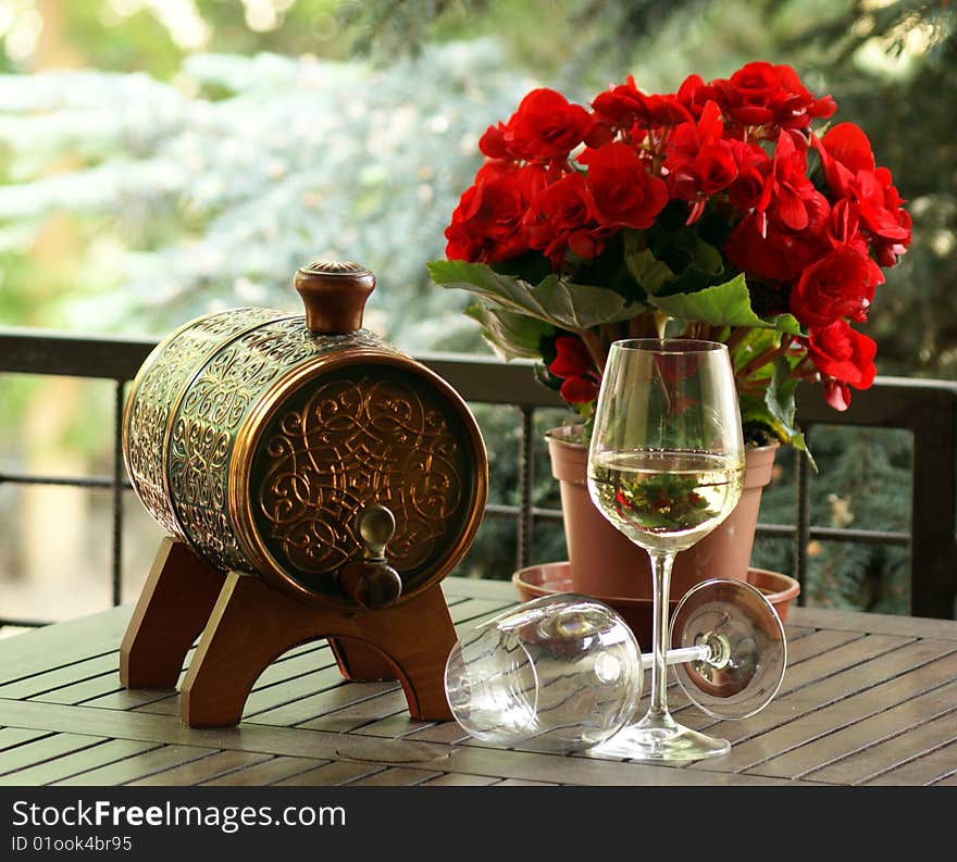 Wine with begonia in a wood table