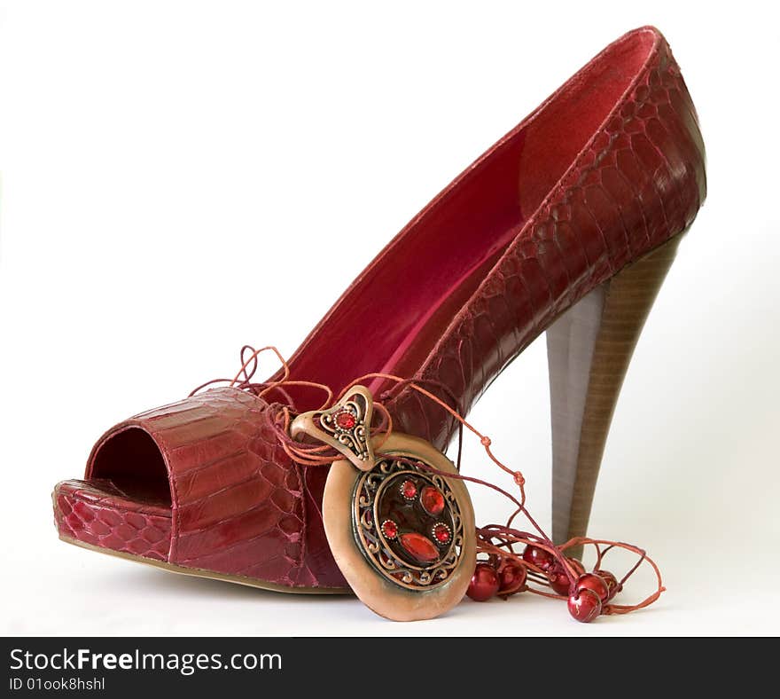 Red shoe with high heel and necklace