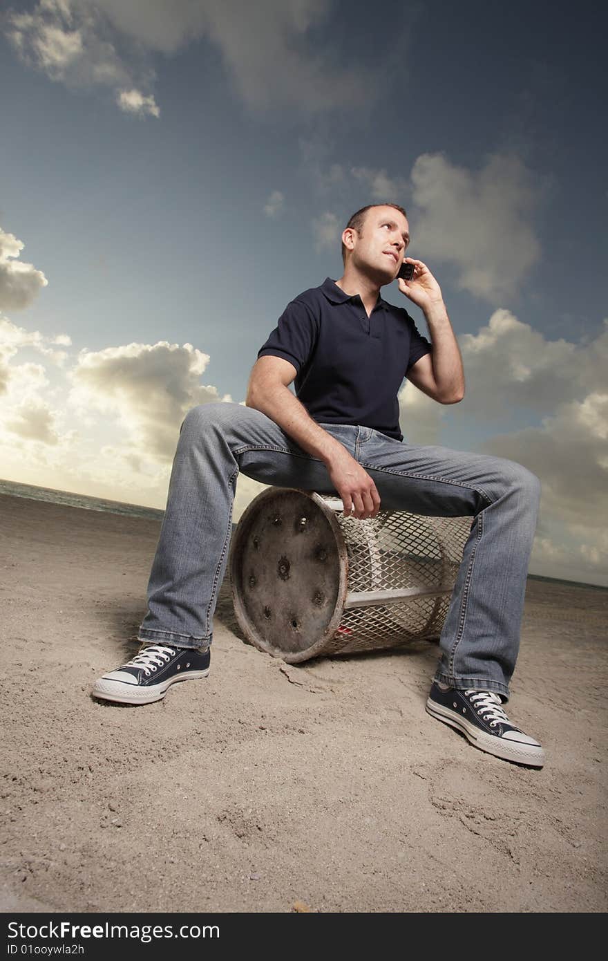 Handsome young man on the beach with a cellphone to his ear. Handsome young man on the beach with a cellphone to his ear