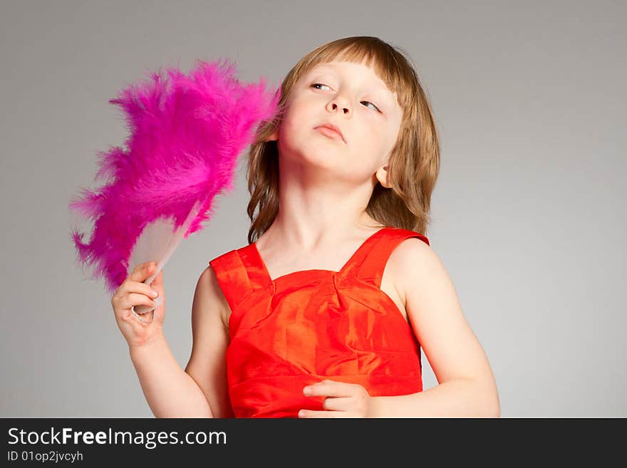 Beauty little girl fan herself. Pink fantail and red dress.