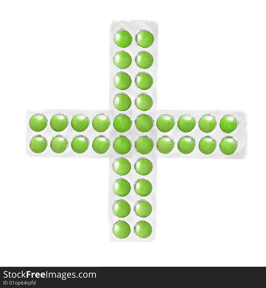 Cross from packs of green tablets isolated on white