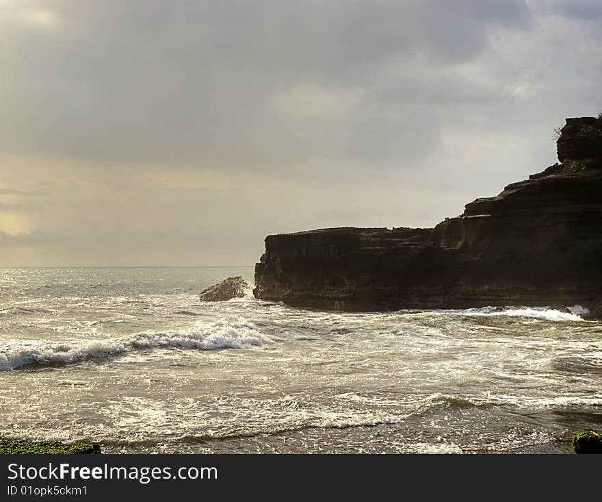 Bali island rocky coast at sunset in stormy weather