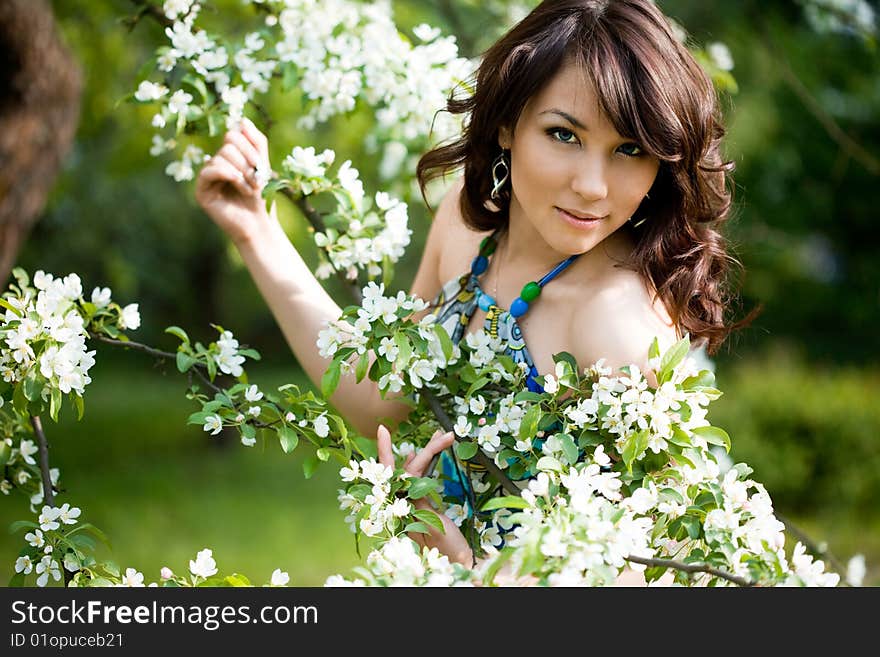 Tender girl in the garden with flowerings trees