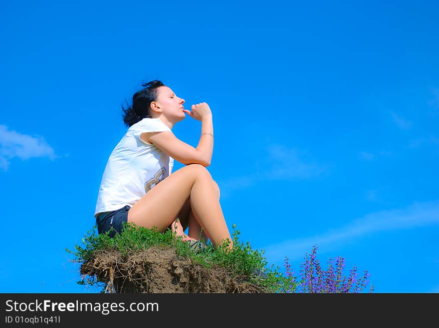 Girl sitting on a top of a hill. Girl sitting on a top of a hill