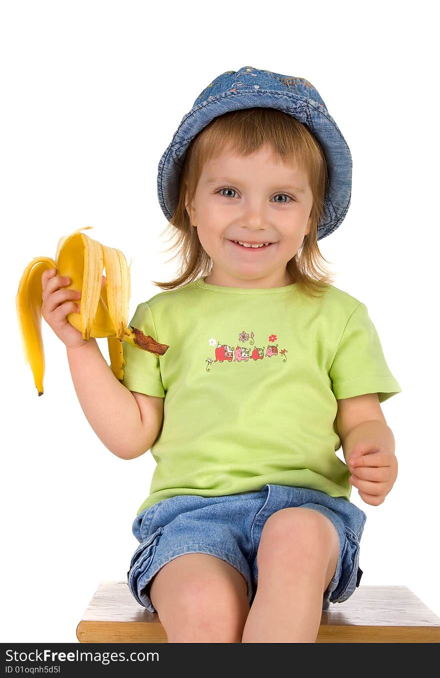 Little girl eats a banana. Studio shot