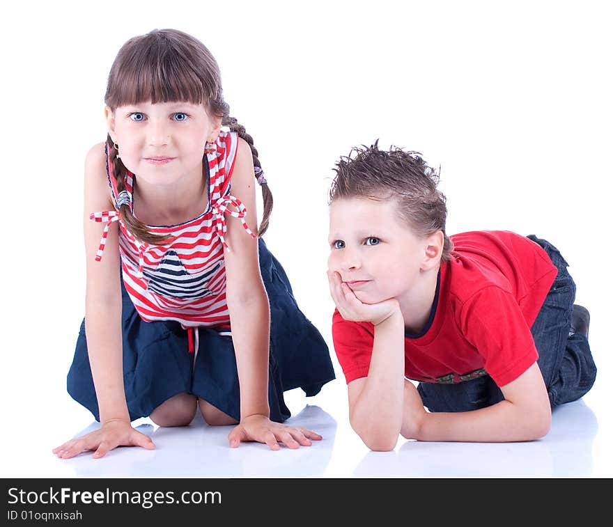 Cute blue-eyed boy and girl posing in the studio