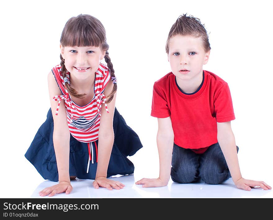 Cute blue-eyed boy and girl posing in the studio