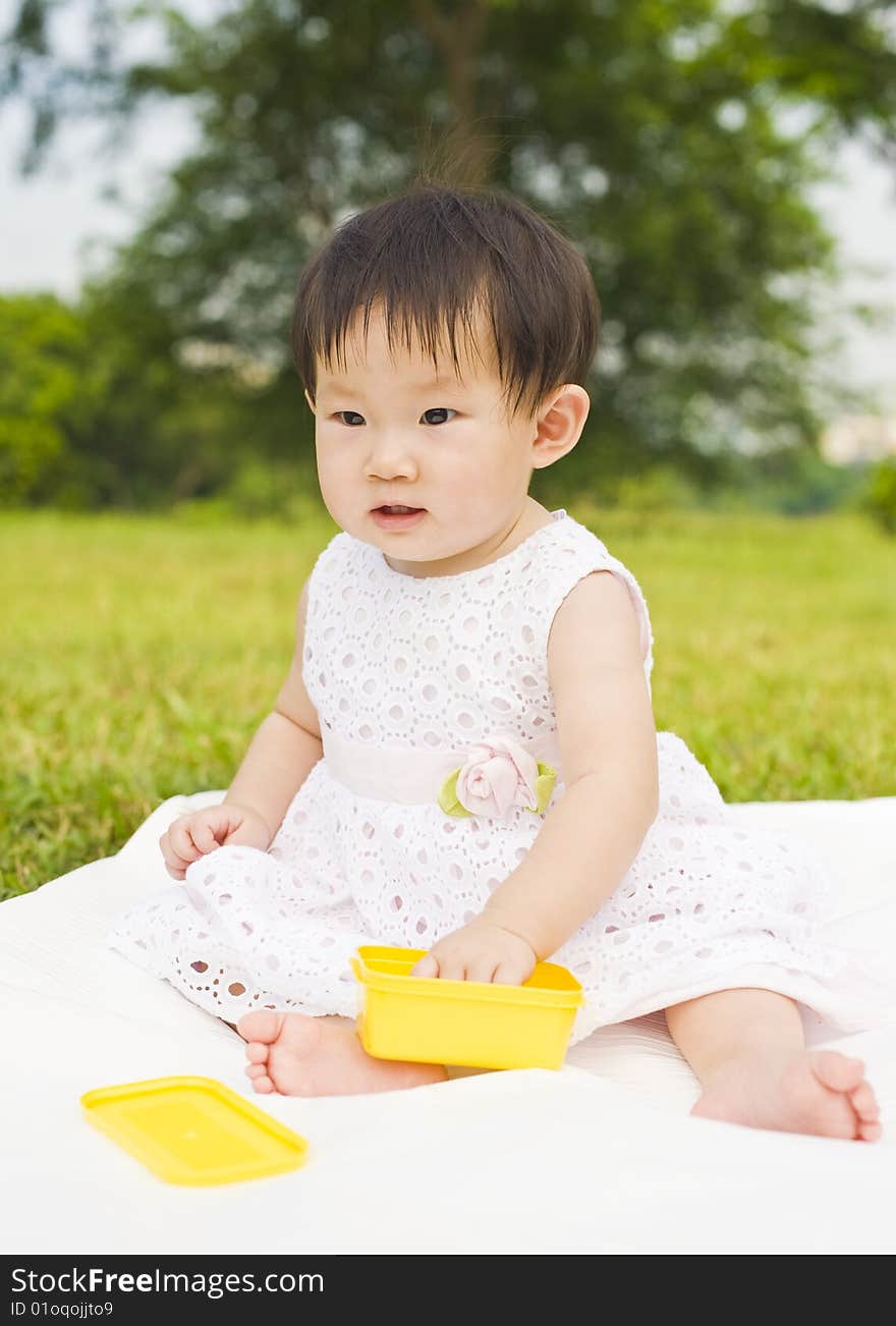 Portrait of an asian infant girl taken outdoors in an open park. Portrait of an asian infant girl taken outdoors in an open park