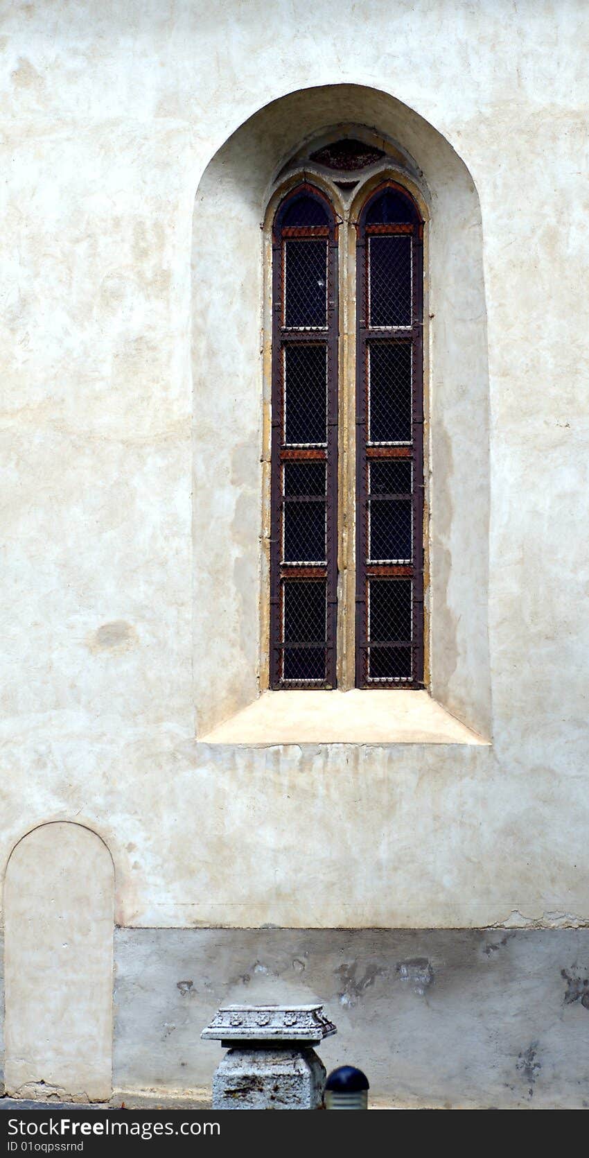 Old Gothic window with white gray facade