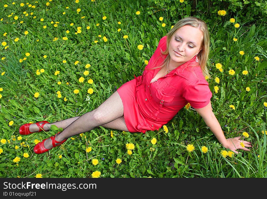 Young girl sitting in dandelion meadow