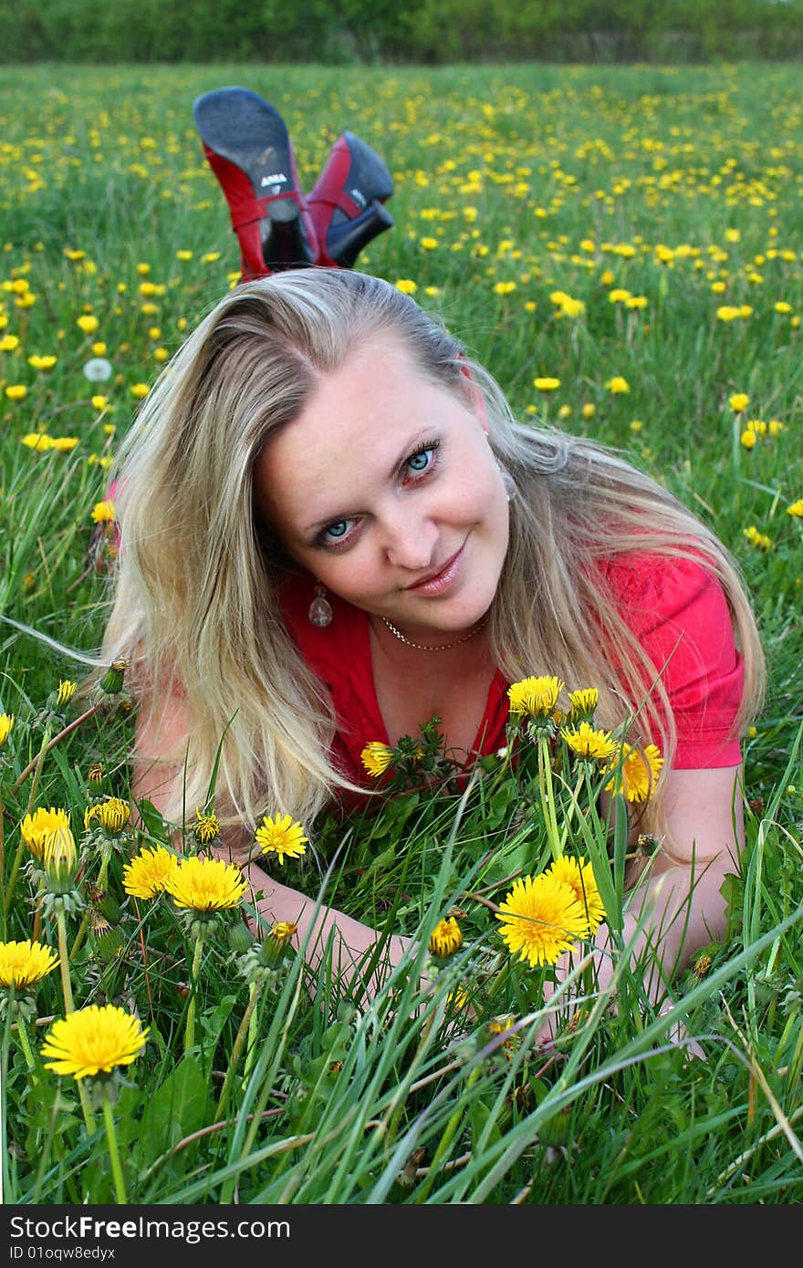 Young girl lying in dandelion meadow