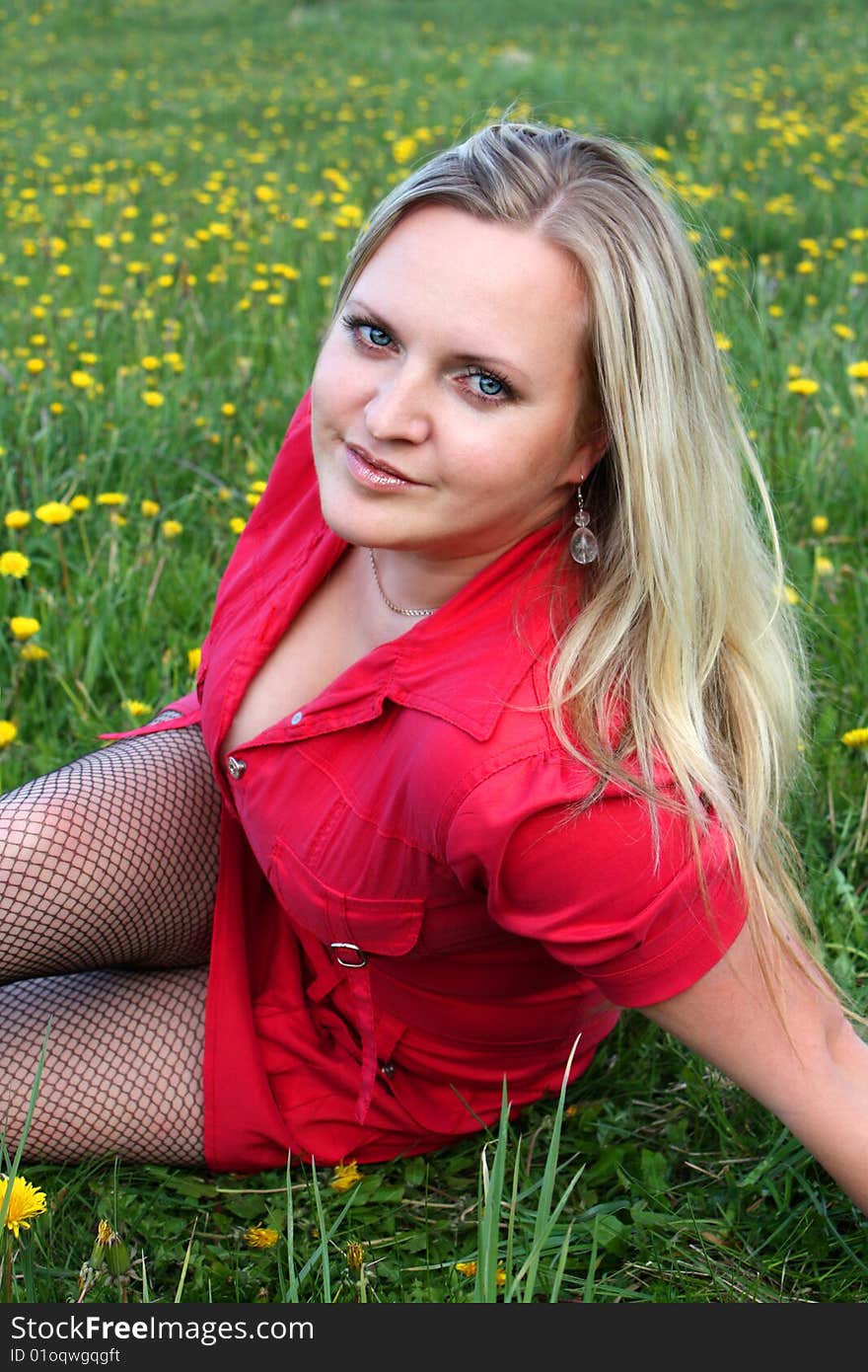 Young girl sitting in dandelion meadow. Young girl sitting in dandelion meadow