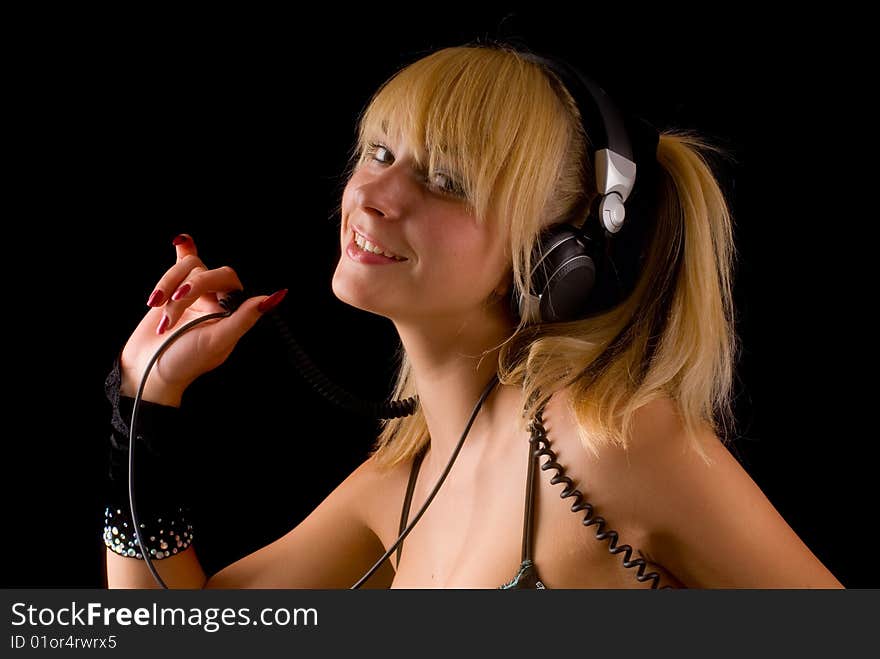 Portrait of a young girl with headphones on a black background. Portrait of a young girl with headphones on a black background