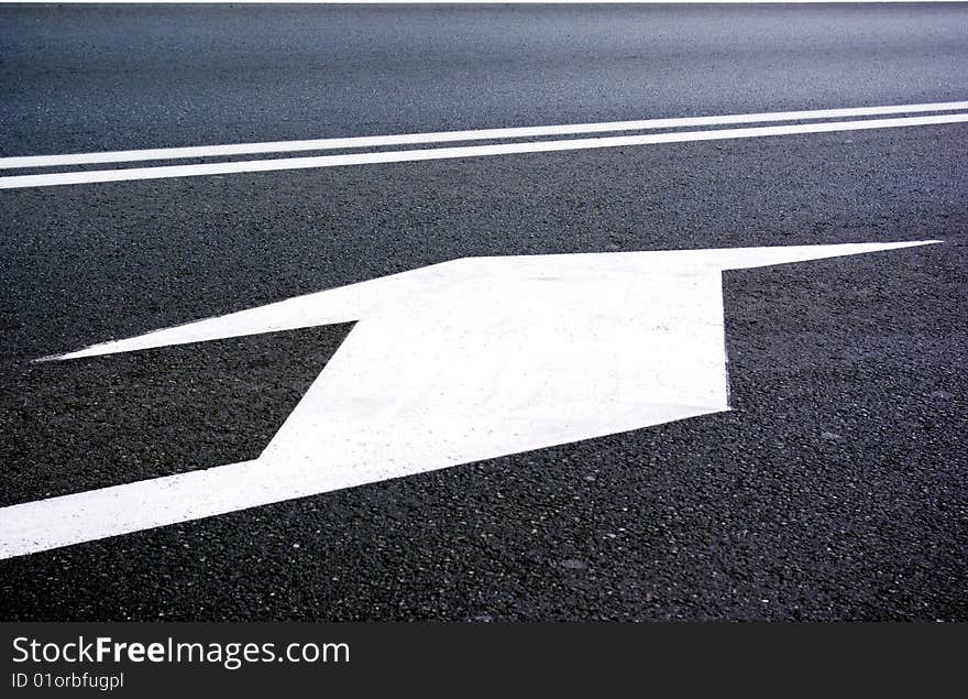 White sign on the road to turn left