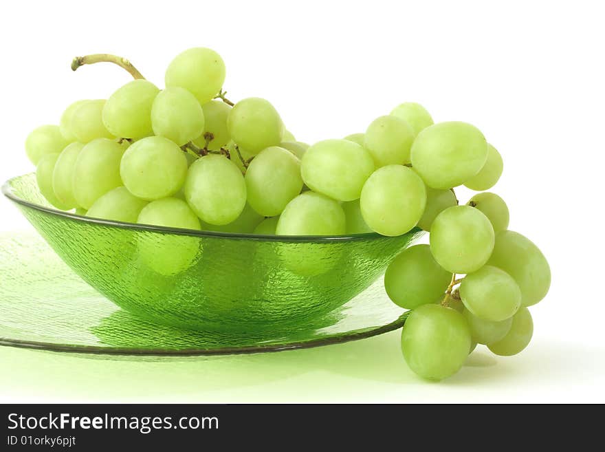 Green grape in the glass plates on a white background. Green grape in the glass plates on a white background