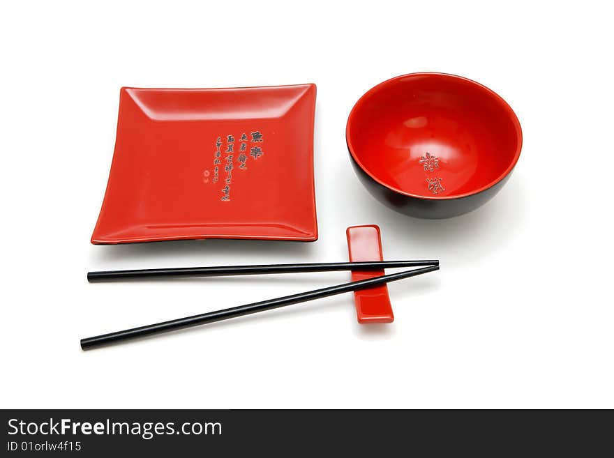 Square red plate, round bowl and chopsticks on stand. Square red plate, round bowl and chopsticks on stand