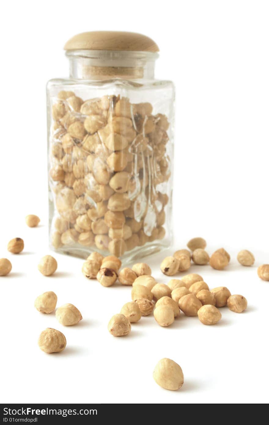 Hazelnuts and glass bank on a white background. Hazelnuts and glass bank on a white background