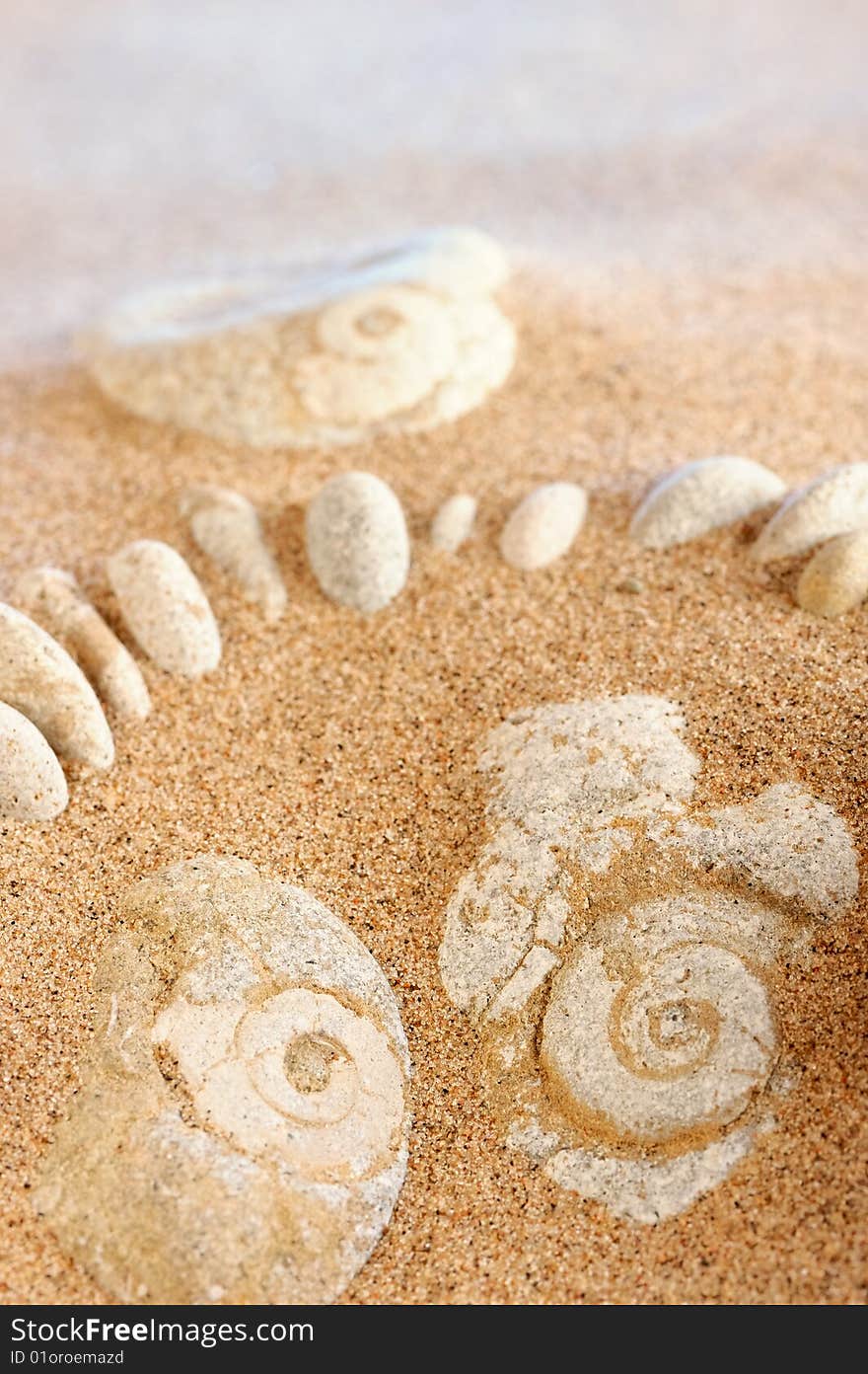 Different white cobblestones put into the sand. Different white cobblestones put into the sand