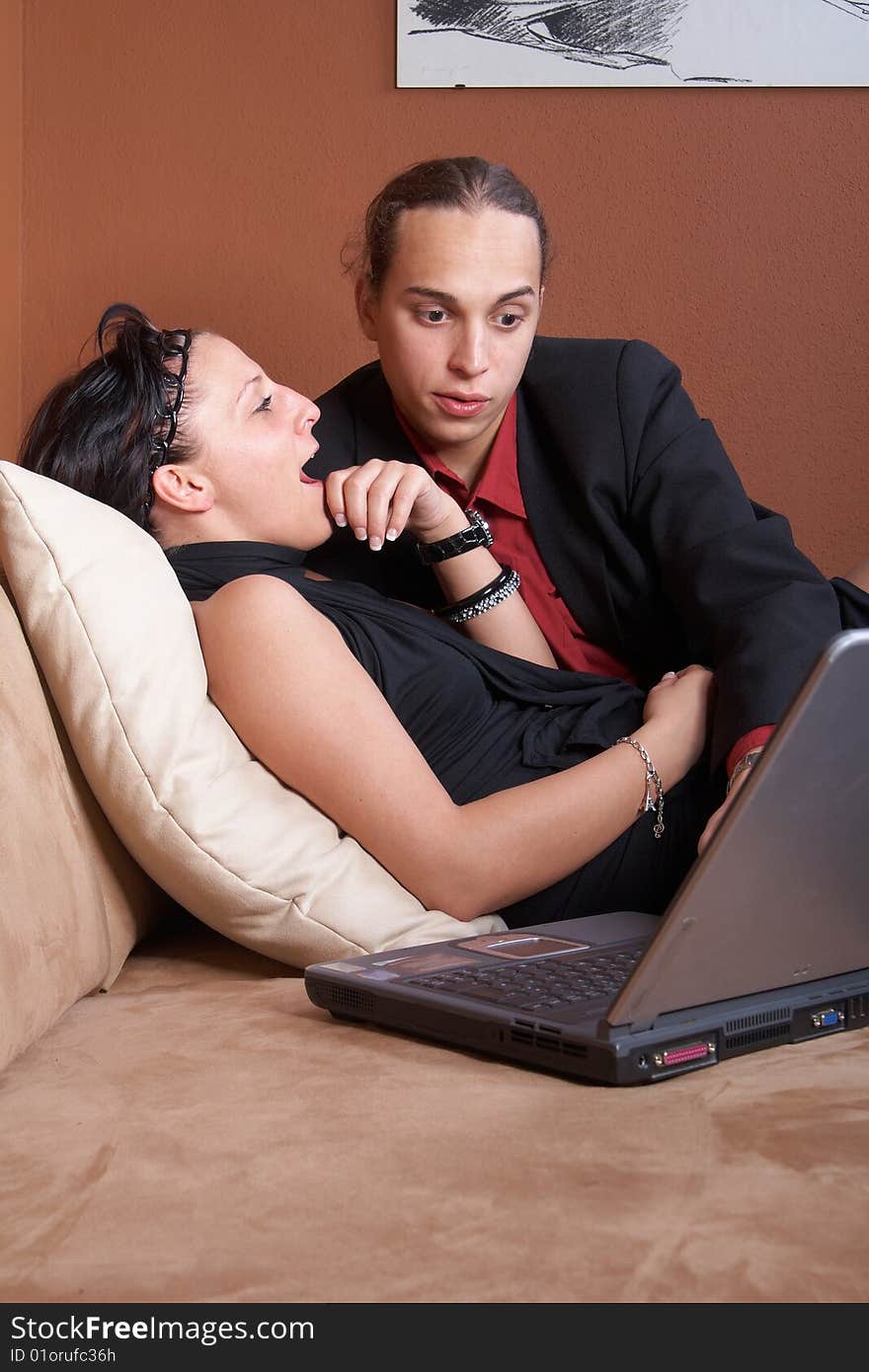 Couple with laptop on couch