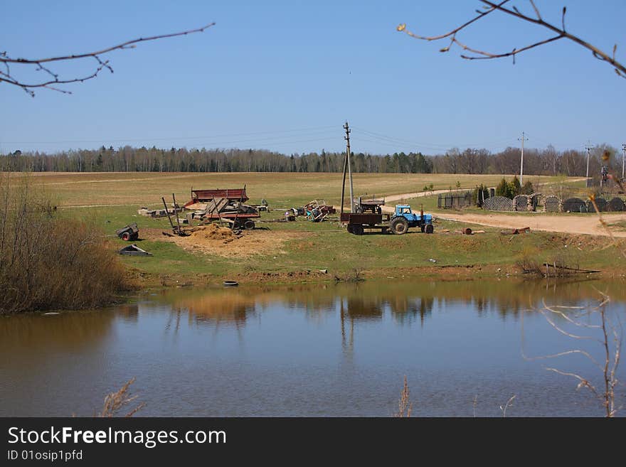 Landscape with old tractors against lake