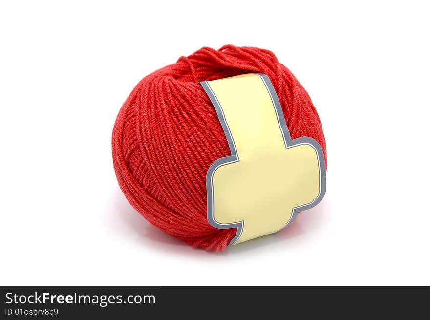 Ball of a red wool with yellow label. White background.