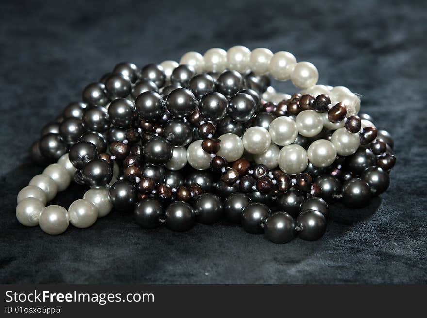 Three NECKLACES FROM pearls on a black velvet