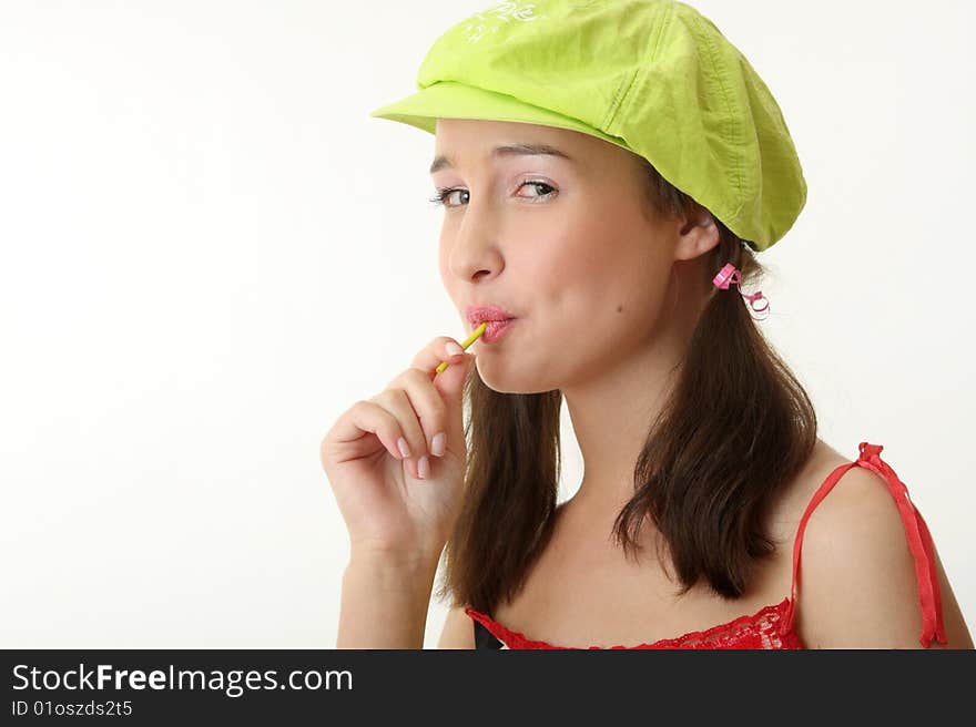 The girl in a green cap eats a sugar candy