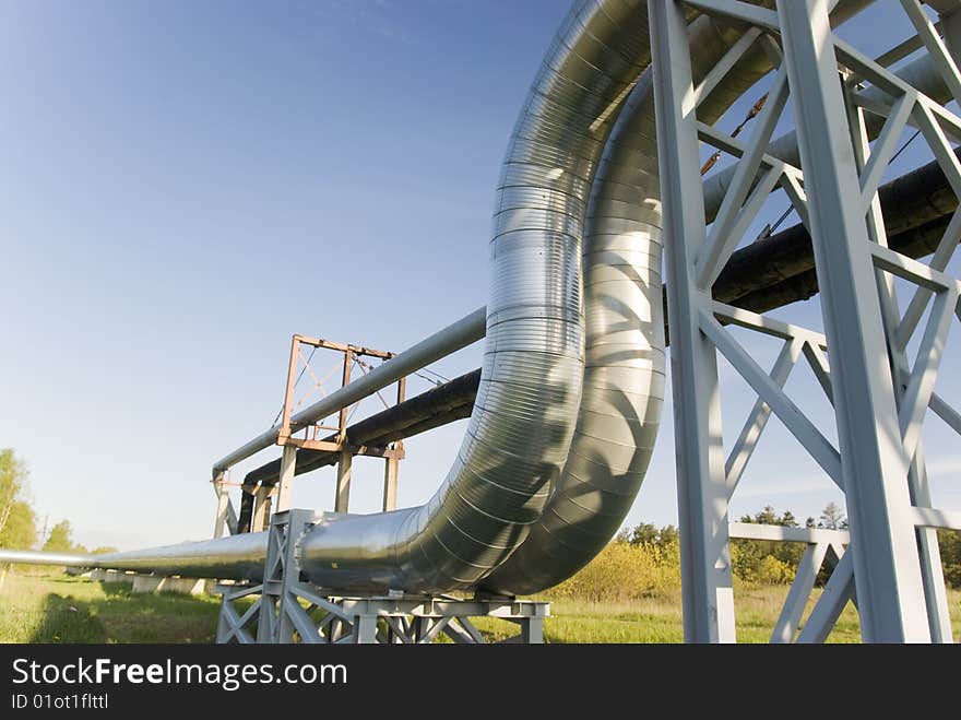 Industrial pipelines on pipe-bridge against blue sky. Industrial pipelines on pipe-bridge against blue sky.