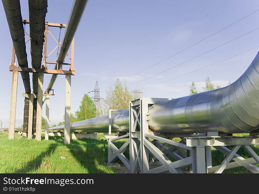 Industrial pipelines on pipe-bridge against blue sky. Industrial pipelines on pipe-bridge against blue sky.