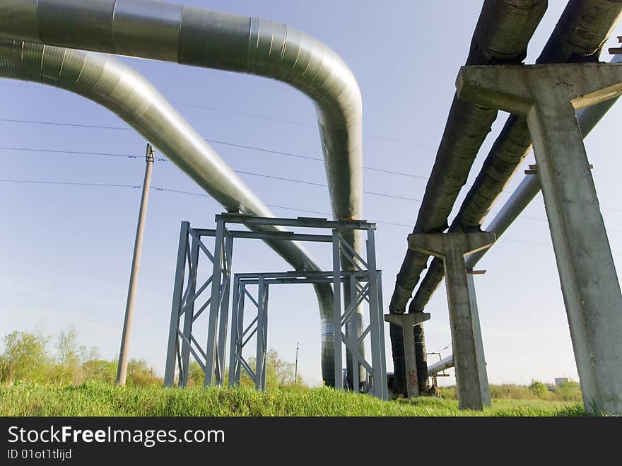 Industrial pipelines on pipe-bridge against blue sky. Industrial pipelines on pipe-bridge against blue sky.