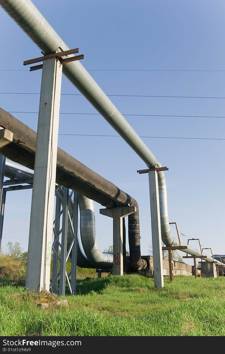 Industrial pipelines on pipe-bridge against blue sky. Industrial pipelines on pipe-bridge against blue sky.