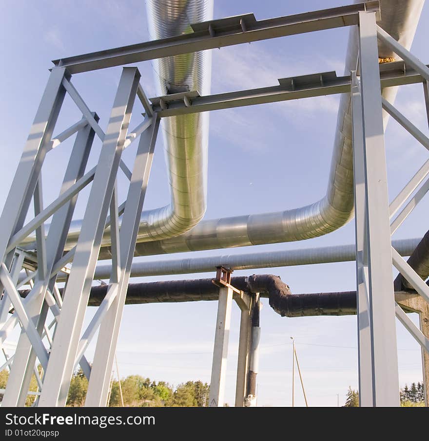 Industrial pipelines on pipe-bridge against blue sky. Industrial pipelines on pipe-bridge against blue sky.