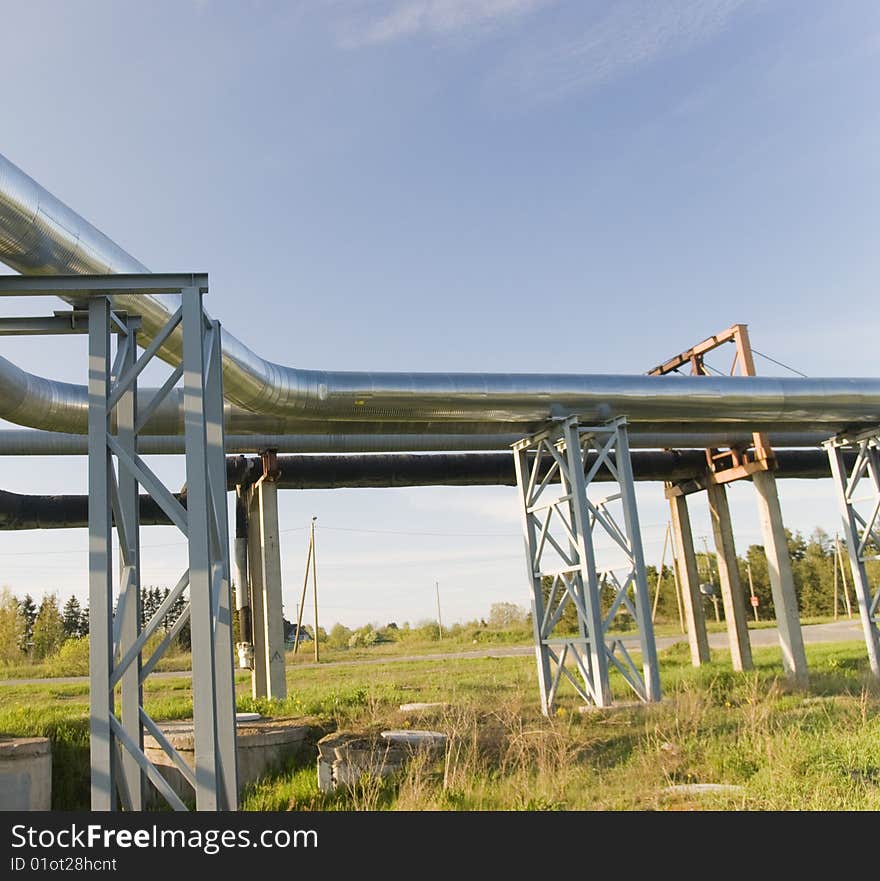 Industrial pipelines on pipe-bridge against blue sky. Industrial pipelines on pipe-bridge against blue sky.