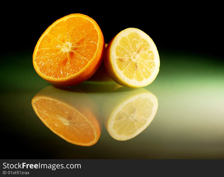 Still life with citruses on the black glass plate