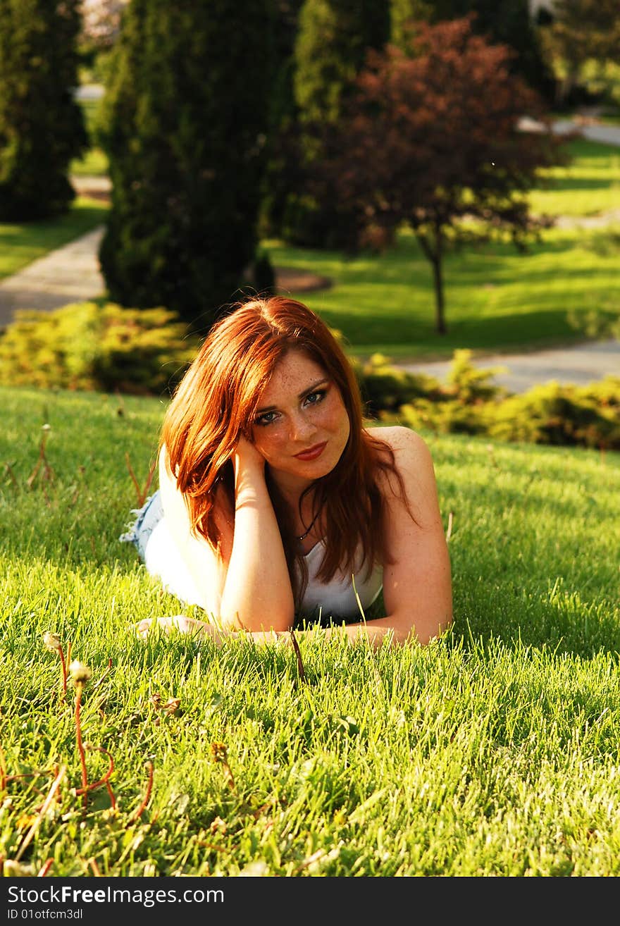 Beautiful red haired girl lying on the grass in an park and enjoying the
gorgeous sunset. Beautiful red haired girl lying on the grass in an park and enjoying the
gorgeous sunset.