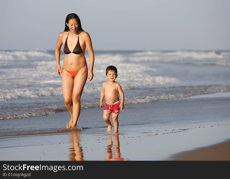 Mother and son running at the beach