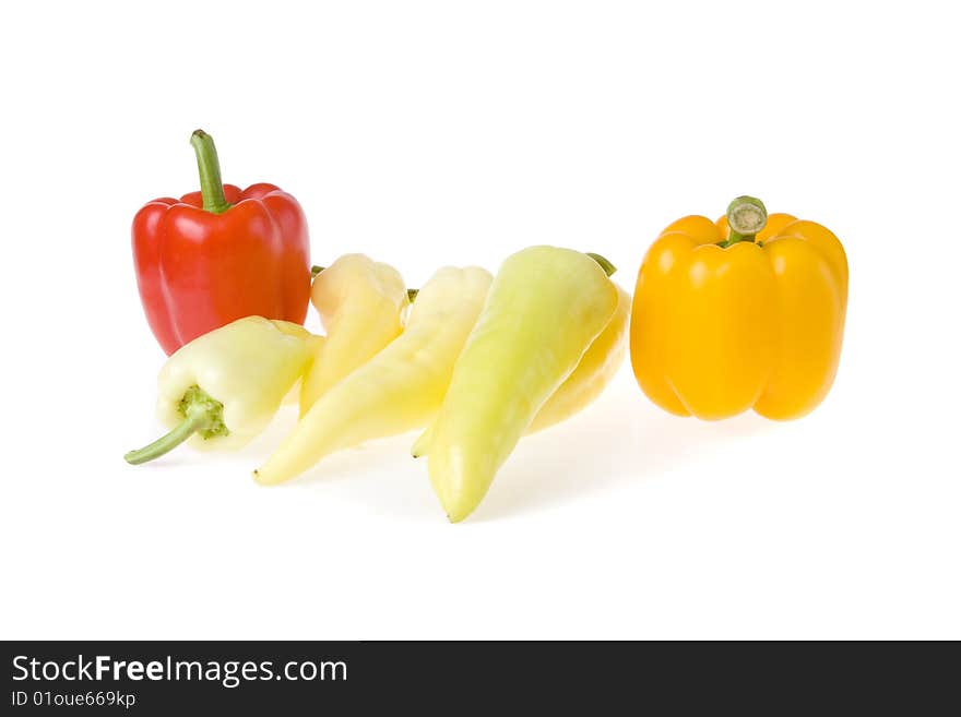 Red, orange and some white peppers on white ground. Red, orange and some white peppers on white ground